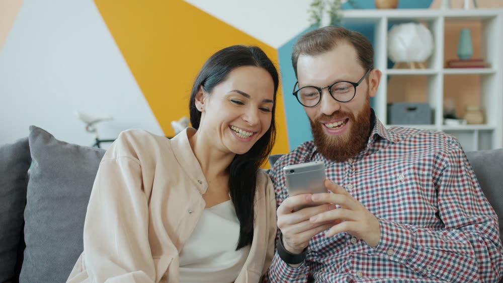 A couple smiling at a phone